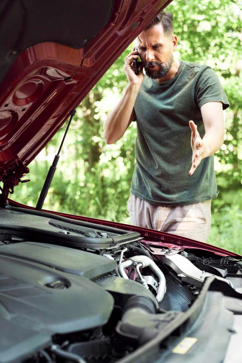 Junger Mann prüft Getriebeschaden bei Schrottauto Ankauf Aachen